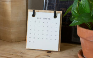 A calendar on a desk with a plant