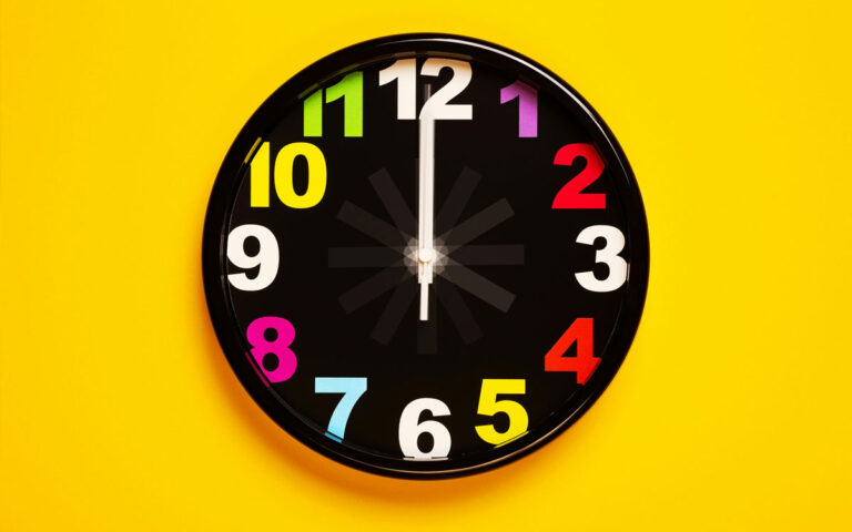 A colourful clock on a yellow background