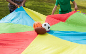 A football, basketball and rugby ball on a tarp